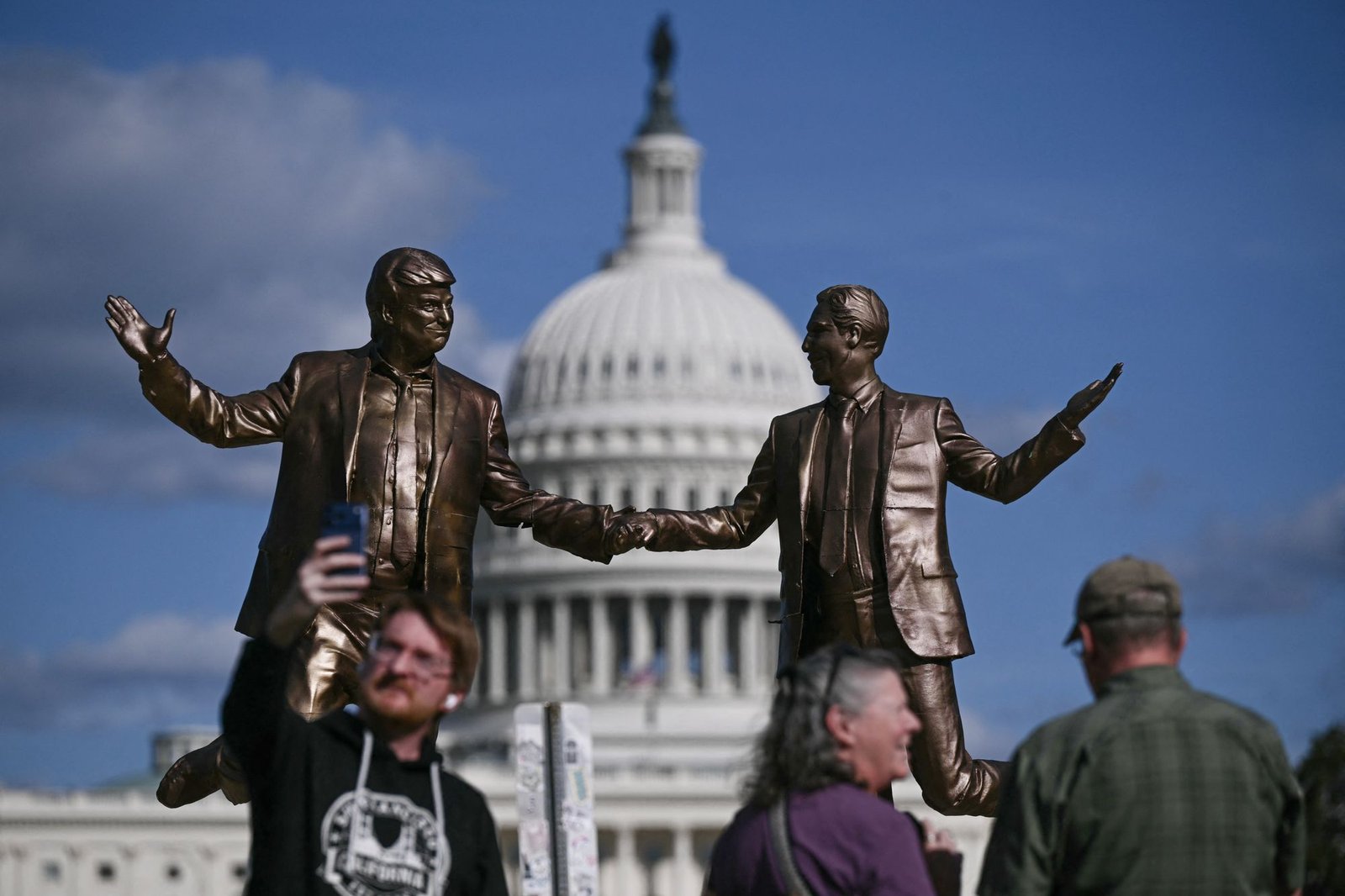 People pose for pictures on Thursday near Epstein-Tram statue.