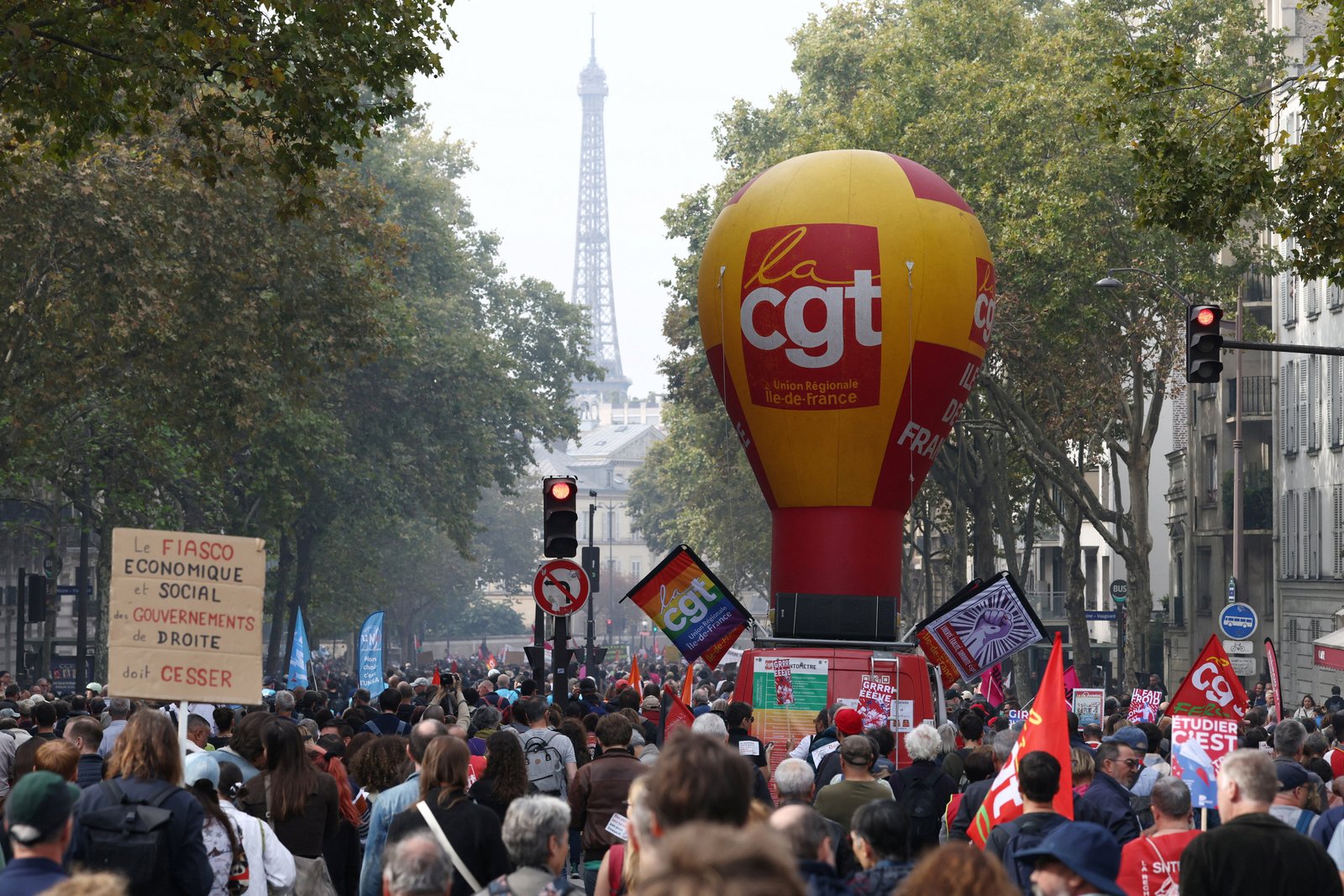 The protesters run next to the CGT Labor Union Balloon, with the Eiffel Tower in the background, as a demonstration during a demonstration in Paris and protests against the government