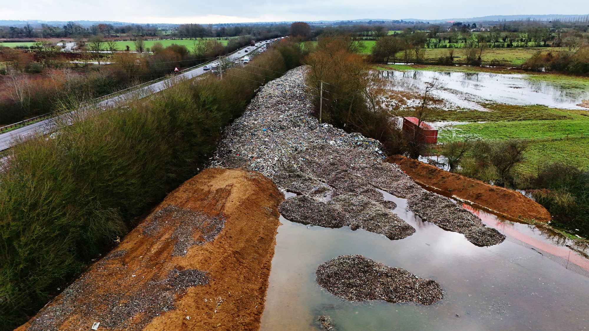 150m long mountain of illegally dumped rubbish beside the A34 in Kidlington and near the River Cherwell