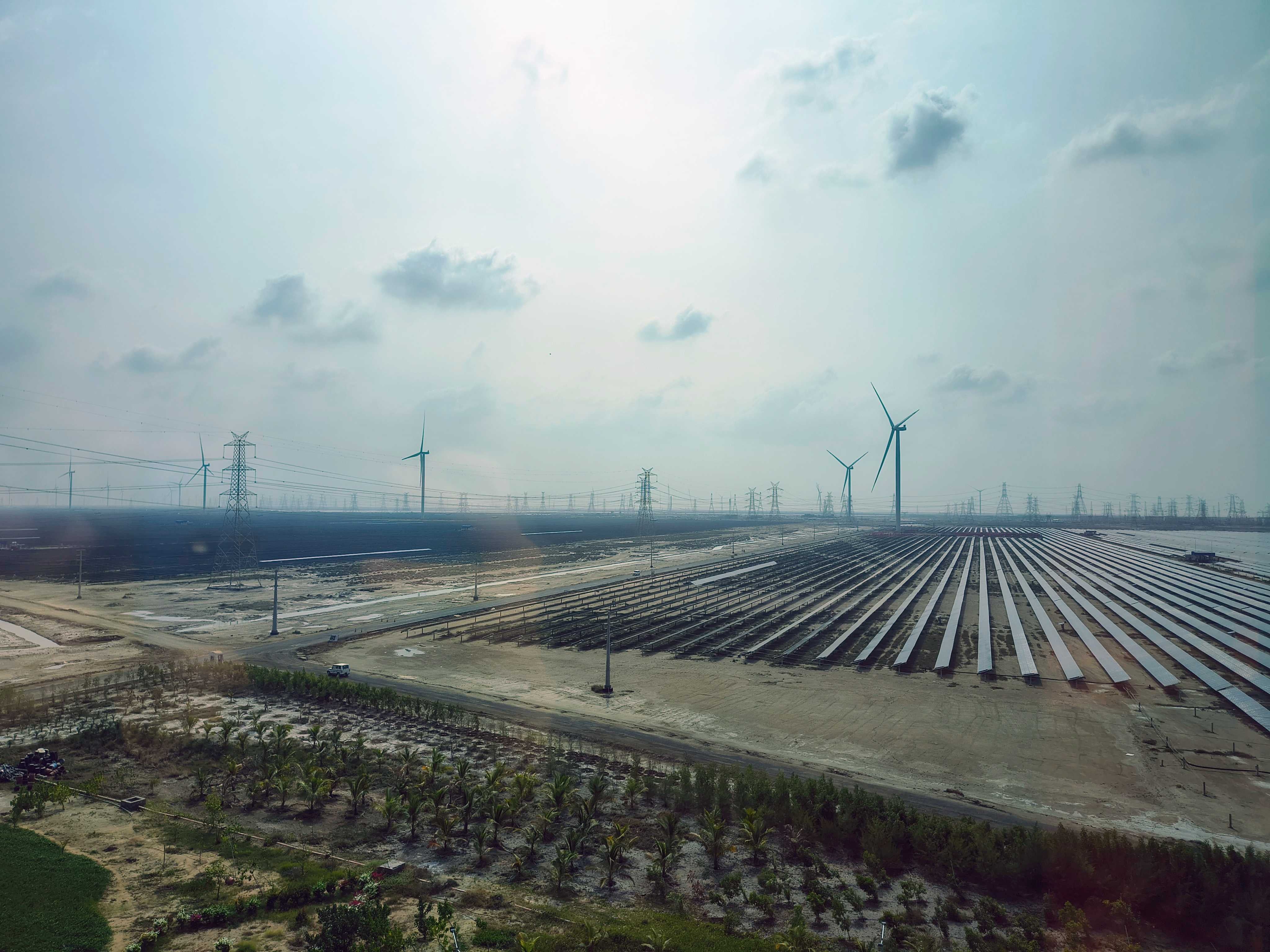 View of the Kafta Renewable Energy Park with rows of solar panels and wind turbines