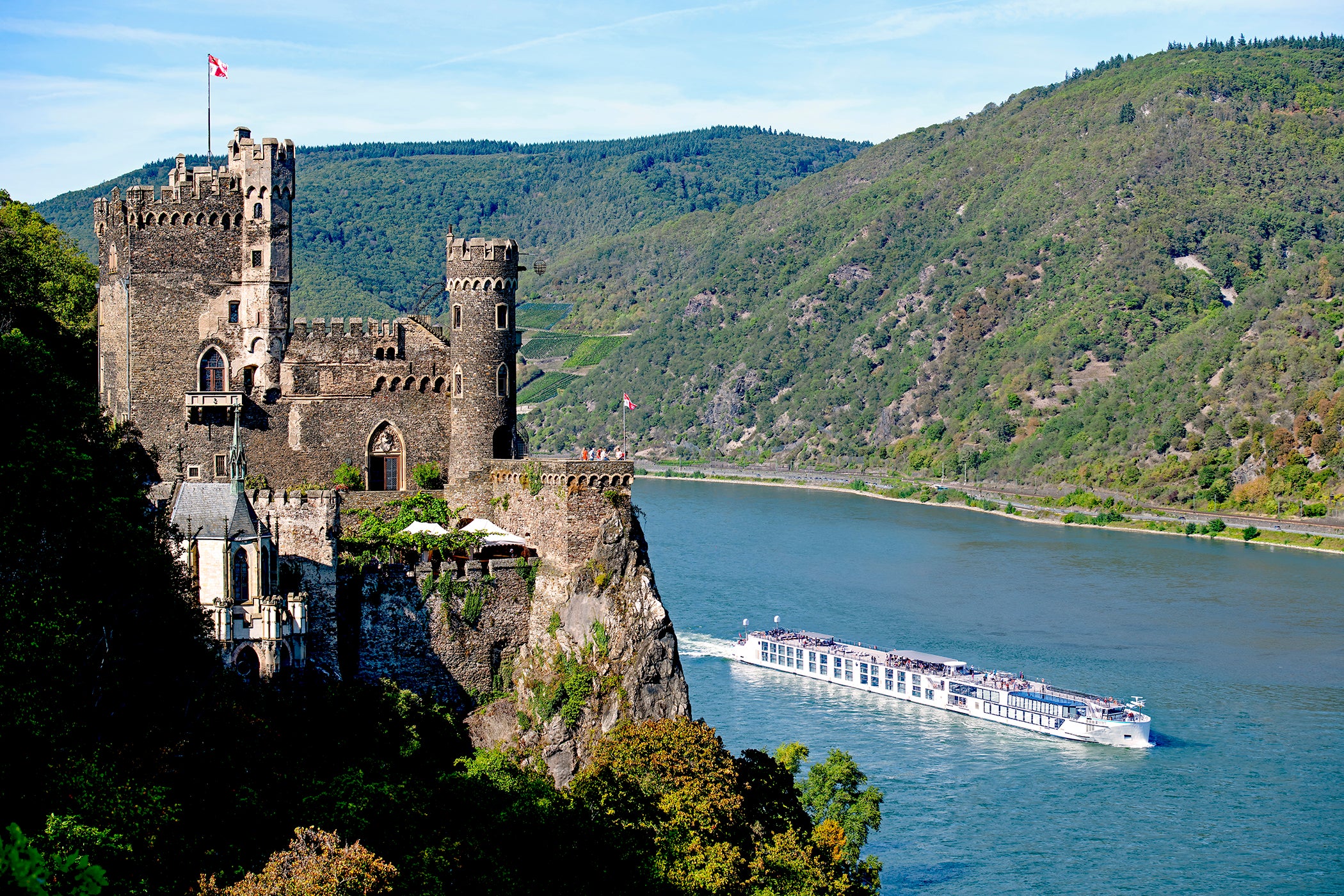 Riverside luxury cruise ship sails past Rheinfels Castle in Germany