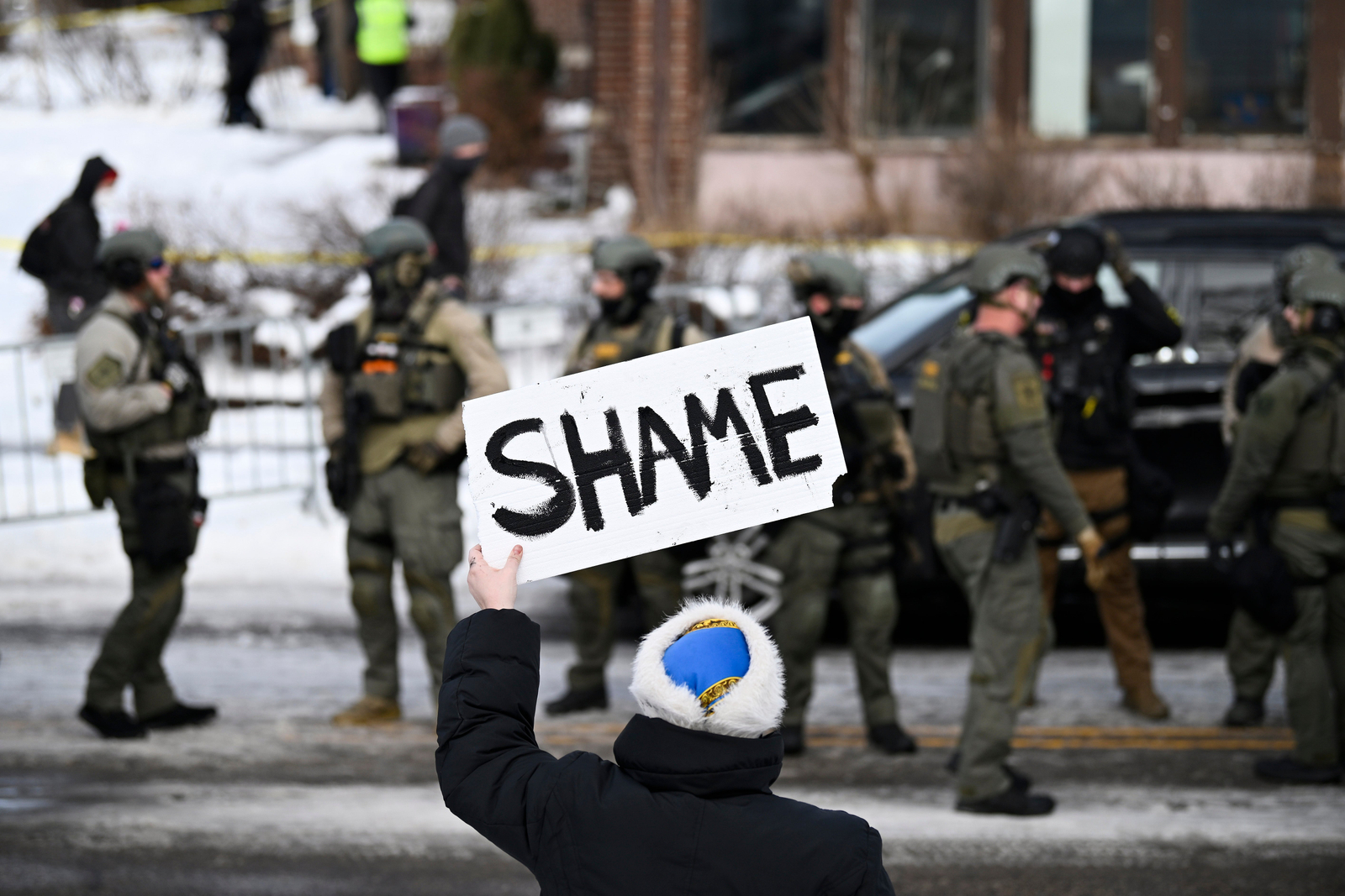 An activist waves an anti-ICE sign in Minneapolis on January 7, the day Renee Nicole Good was shot and killed