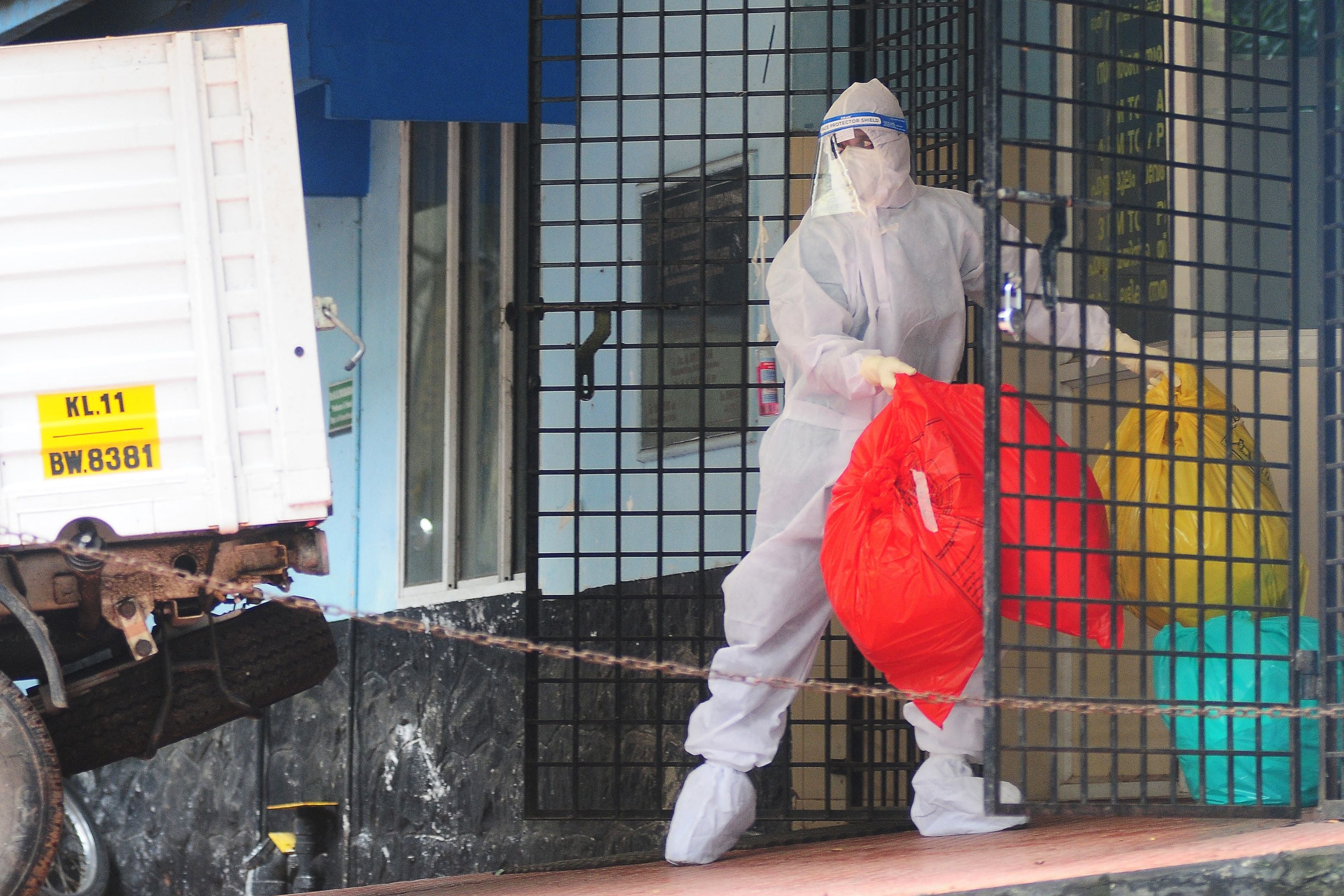 A health worker wearing a protective suit handles biohazard waste at the Nipah Virus Isolation Center at a government hospital in Kozhikode, in the southern Indian state of Kerala