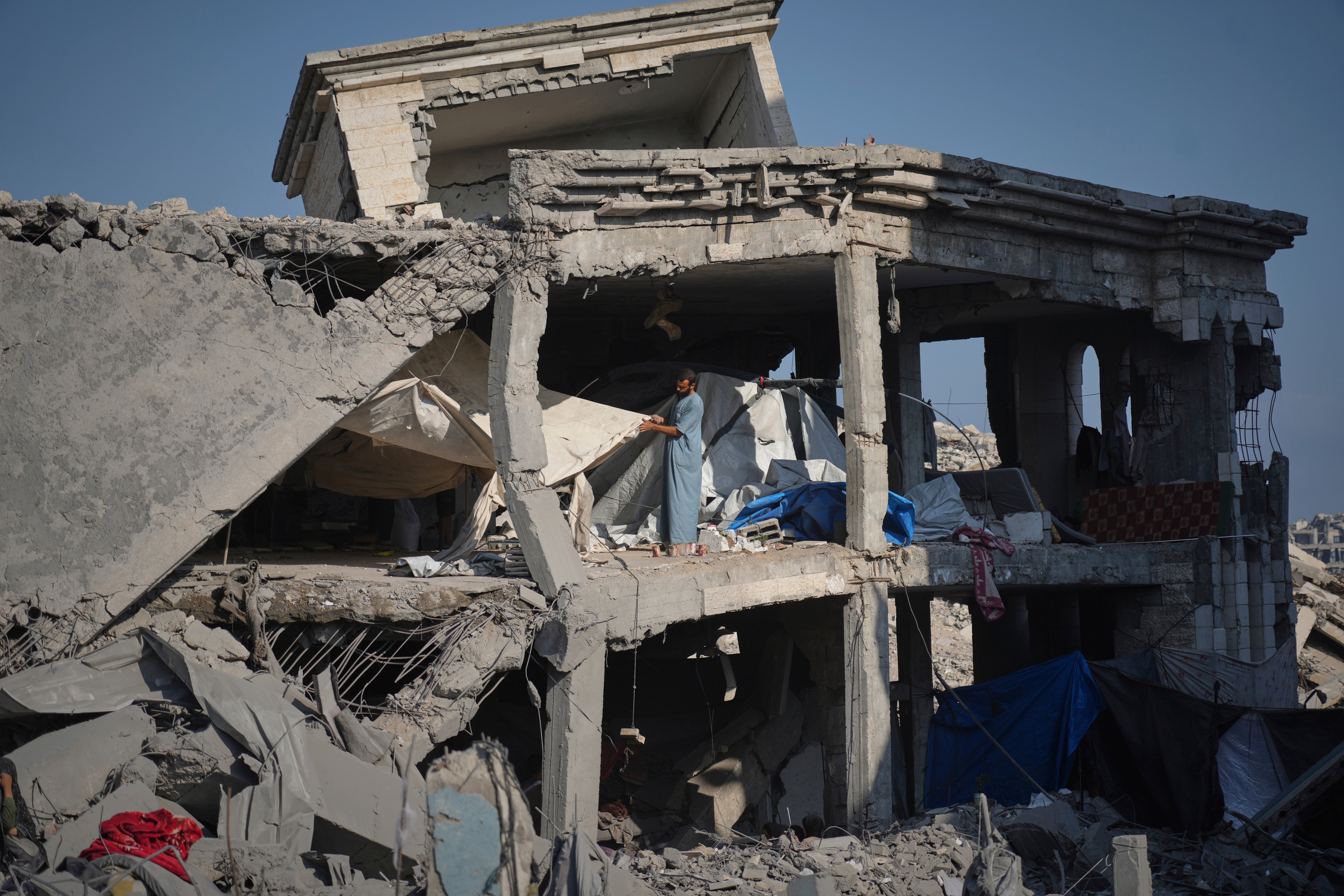 People inspect damage to the UNRWA Sheikh Radwan al-Taba clinic after Israeli forces bombed Gaza City on Wednesday, 6 August 2025. The clinic had been evacuating displaced Palestinians before the attack. (AP Photo/Jehad Alshrafi)