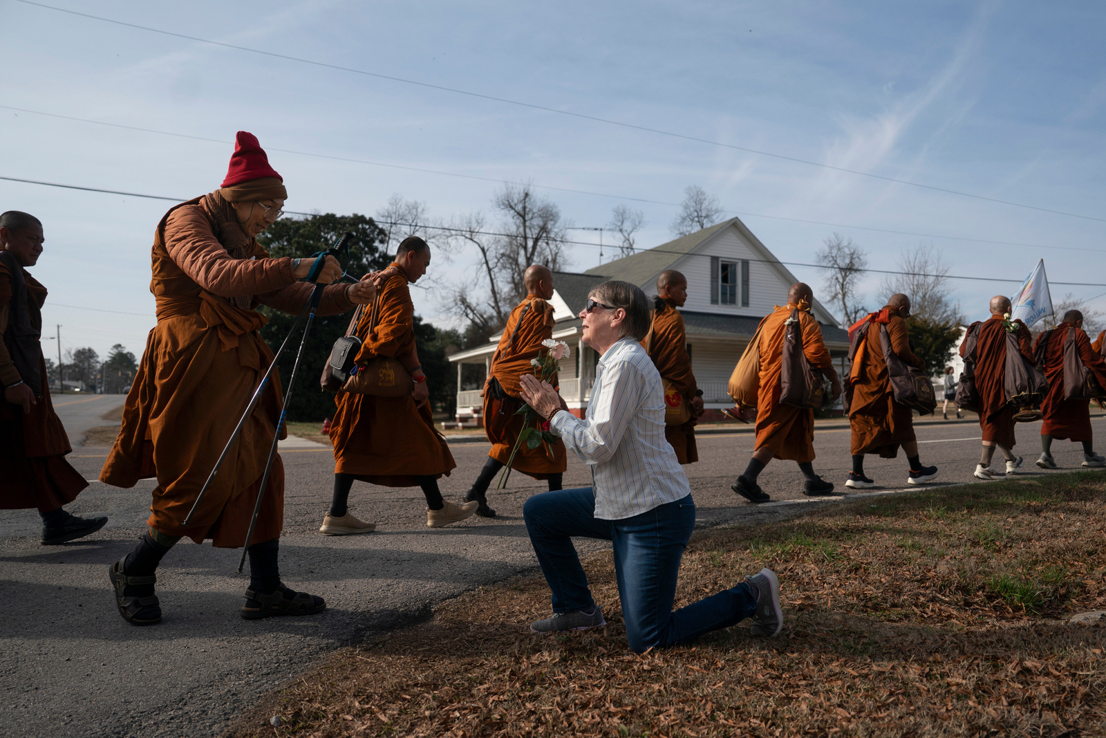 Audrie Pearce greets the Buddhist monks attending the event, 