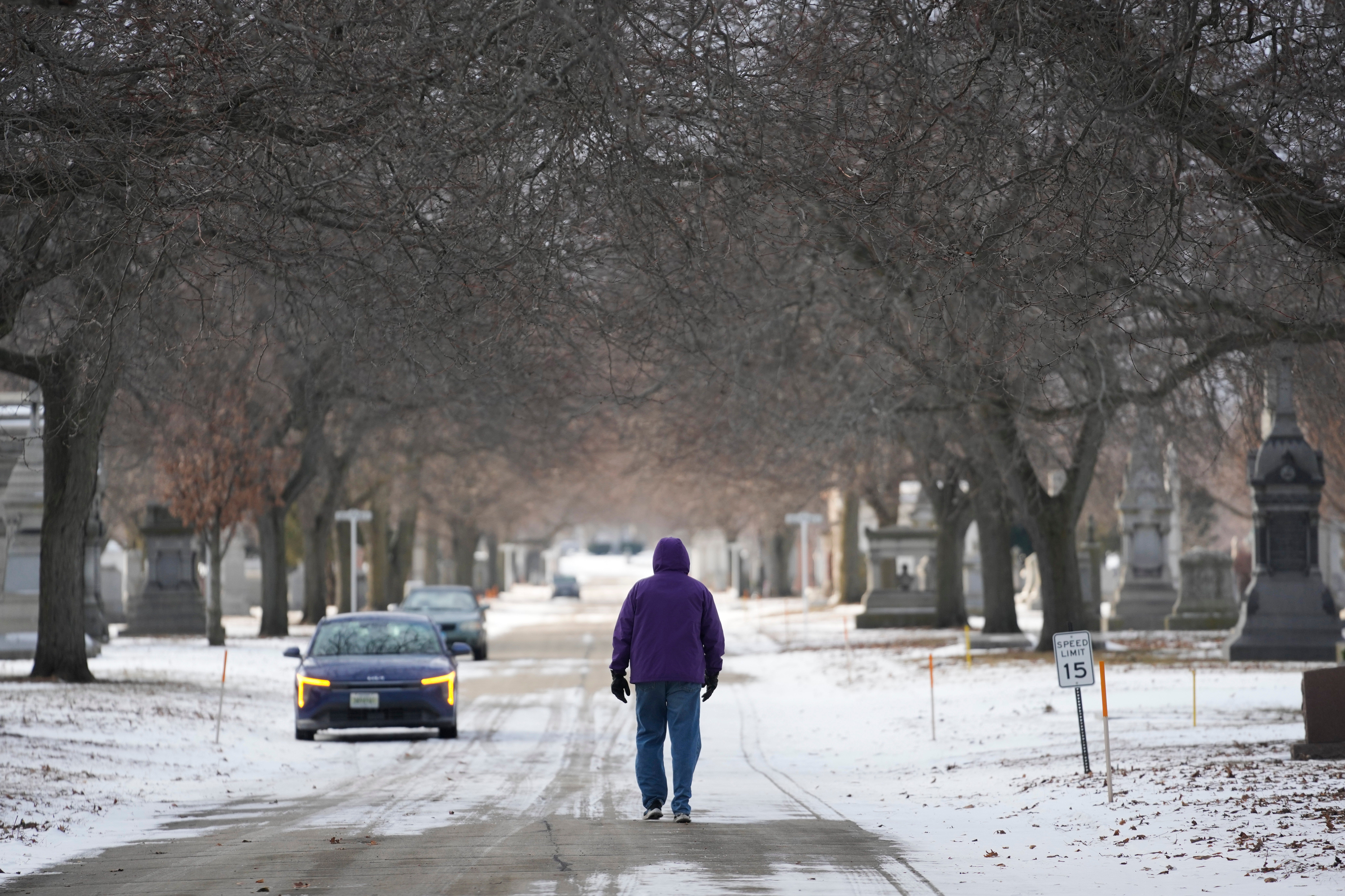 A person walks through the snowy Calvary Catholic Cemetery on Wednesday, January 21, 2026, in Chicago. (AP Photo/Erin Hooley)