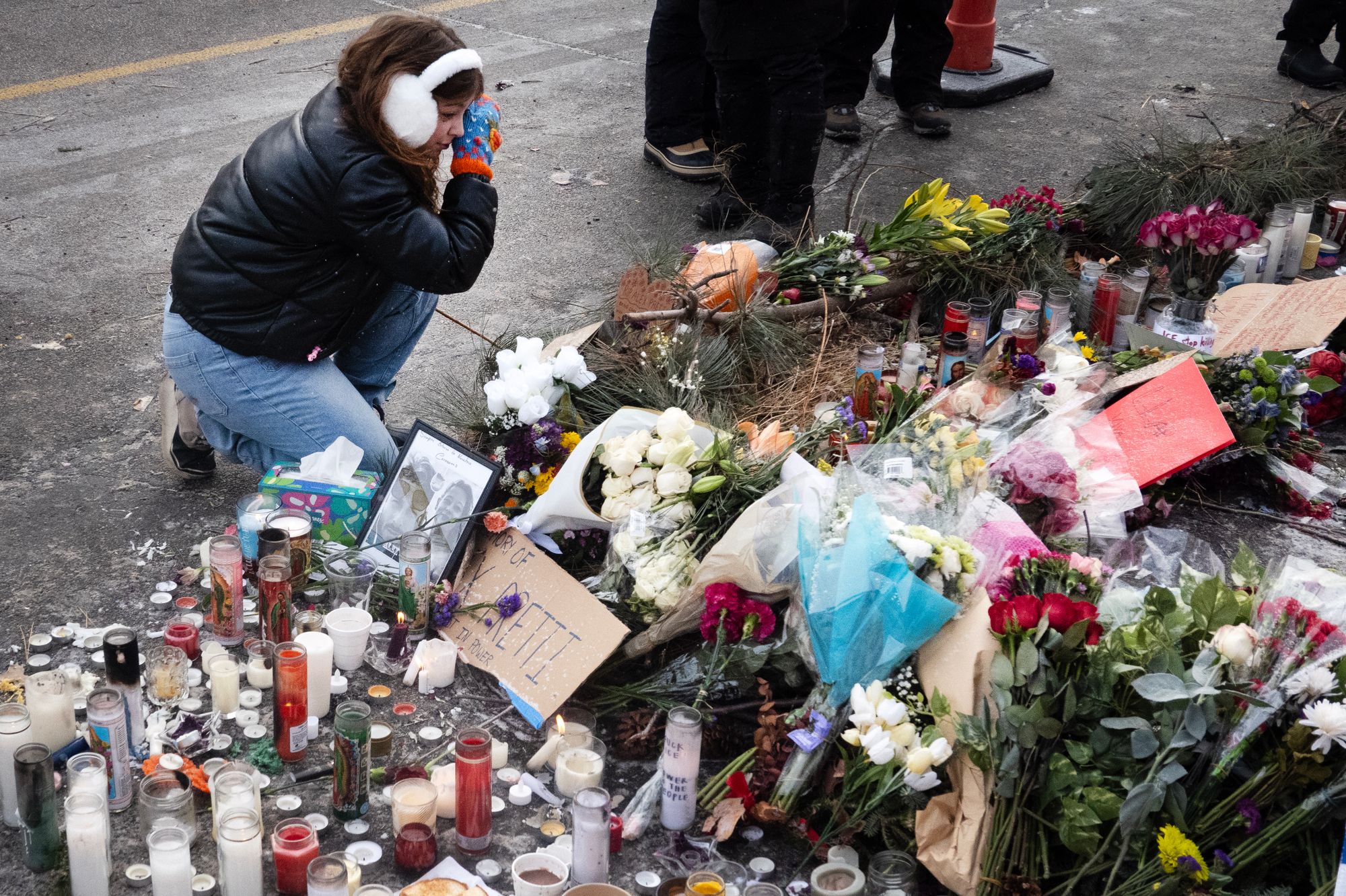 A woman wipes away tears while visiting the Alex Pretti memorial in Minneapolis on January 25, 2026