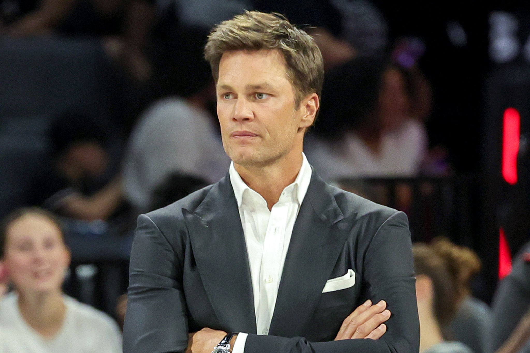 Tom Brady stands court side during a Las Vegas Aces WNBA game. Brady is a minority owner in both the Las Vegas Aces and the Las Vegas Raiders NFL team