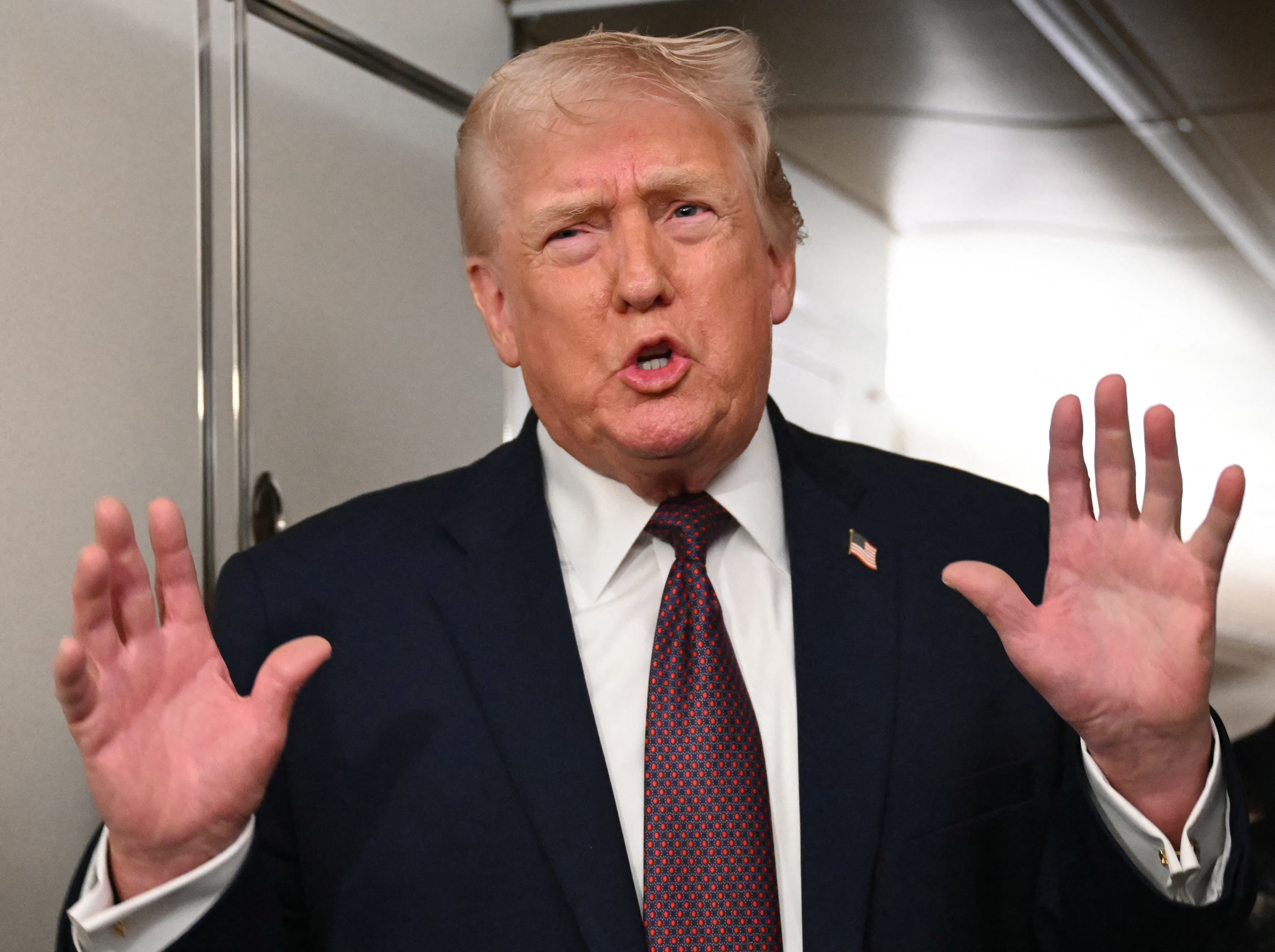 U.S. President Donald Trump speaks to the press aboard Air Force One, Sunday, January 11, 2026