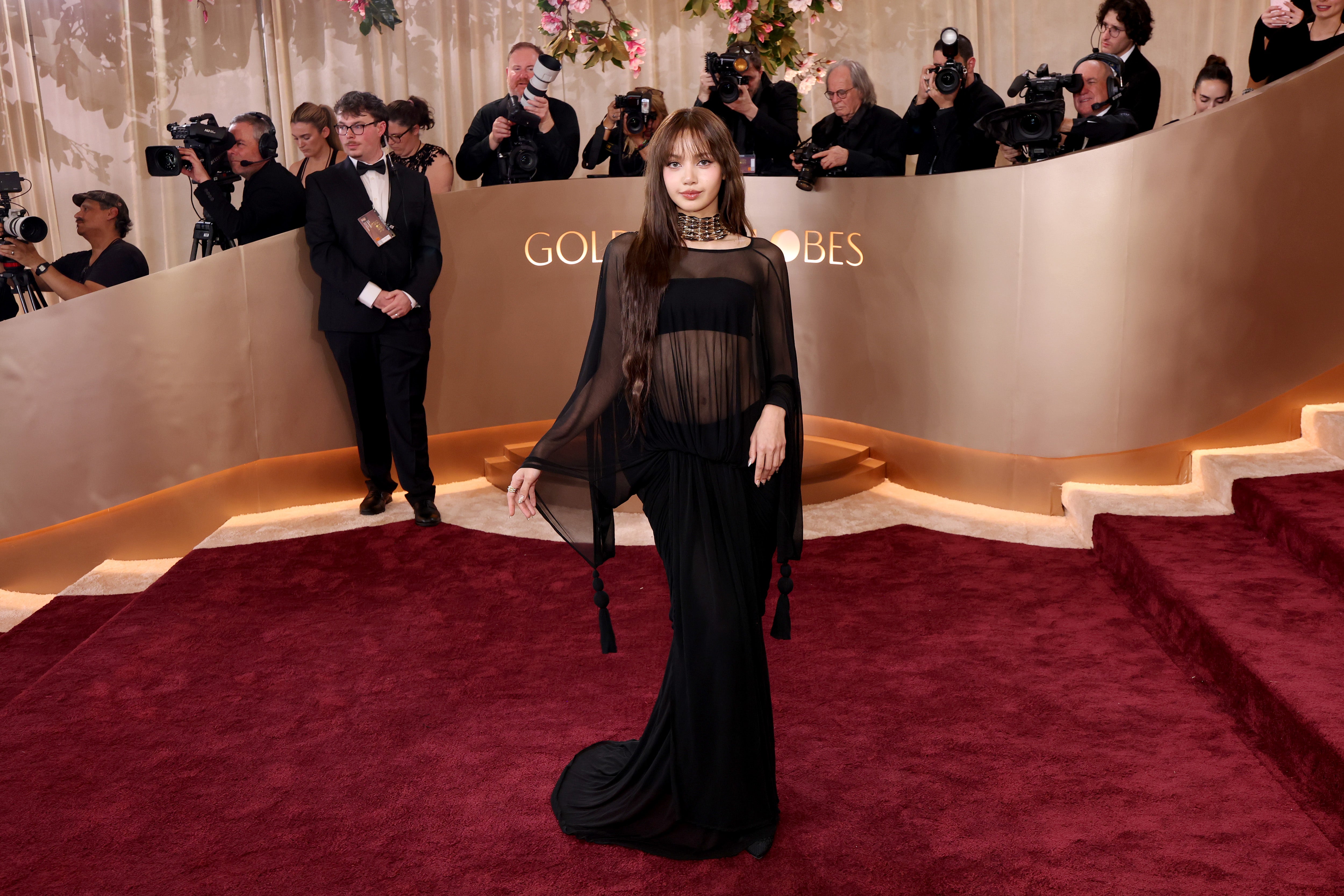 Blackpink member Lisa looked elegant and chic in a stylish sheer black Jacquemus gown with a matching skirt and bandeau. She also chose a silver beaded necklace