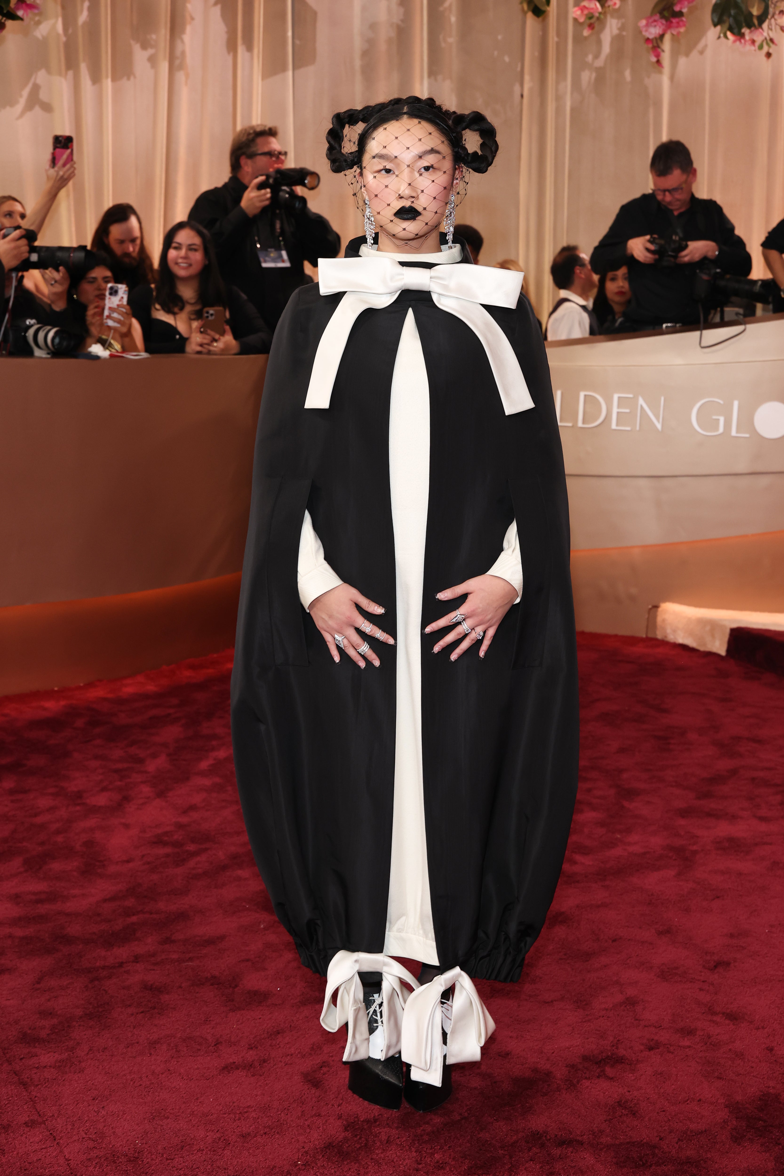 The singer ventured out in a Thom Browne suit, which she paired with a black cape that was topped with a large white bow and tied around her ankles