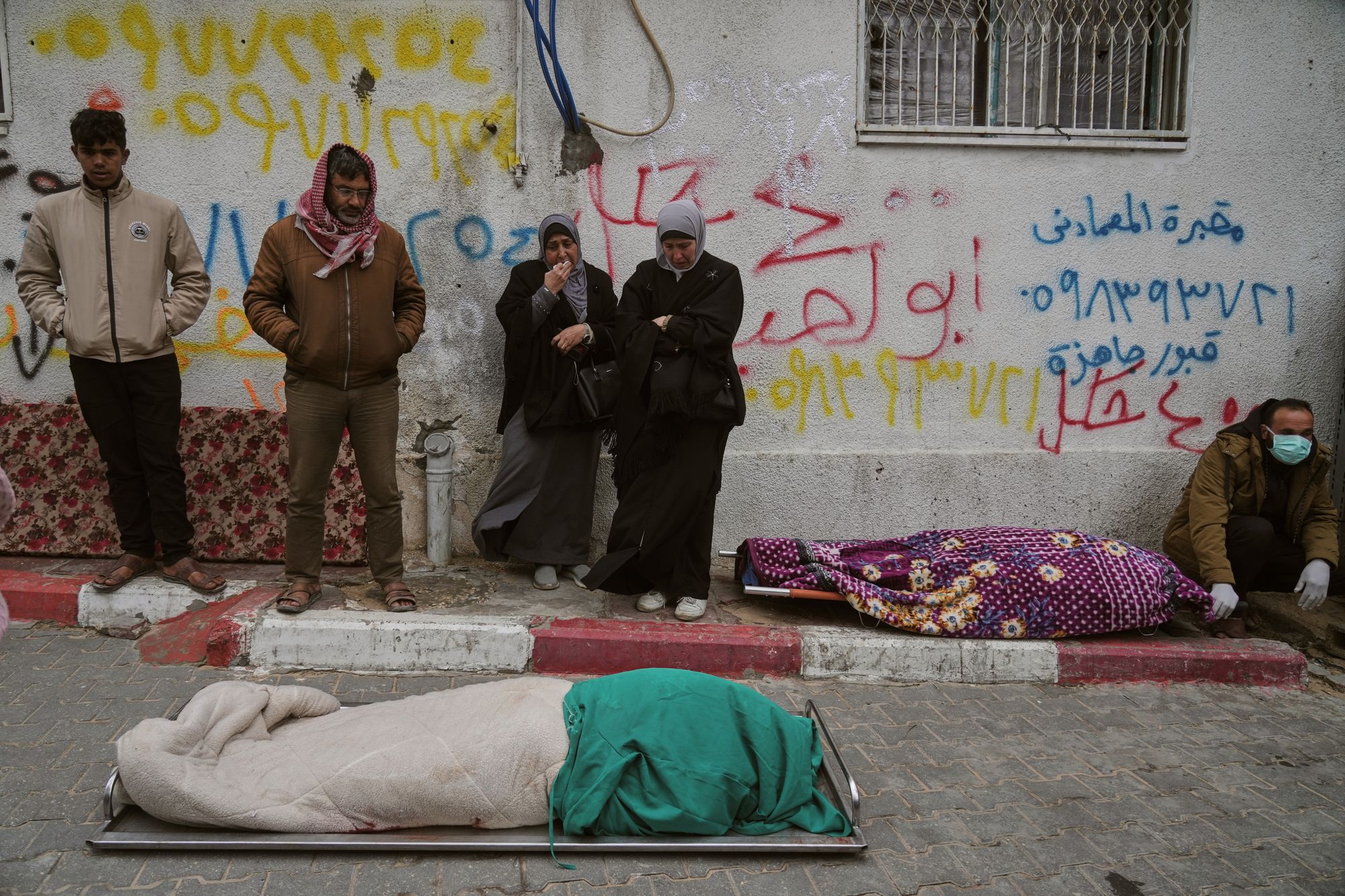 Members of a Hammouda family say goodbye to relatives after a storm-damaged building collapsed on their tent in Gaza City.