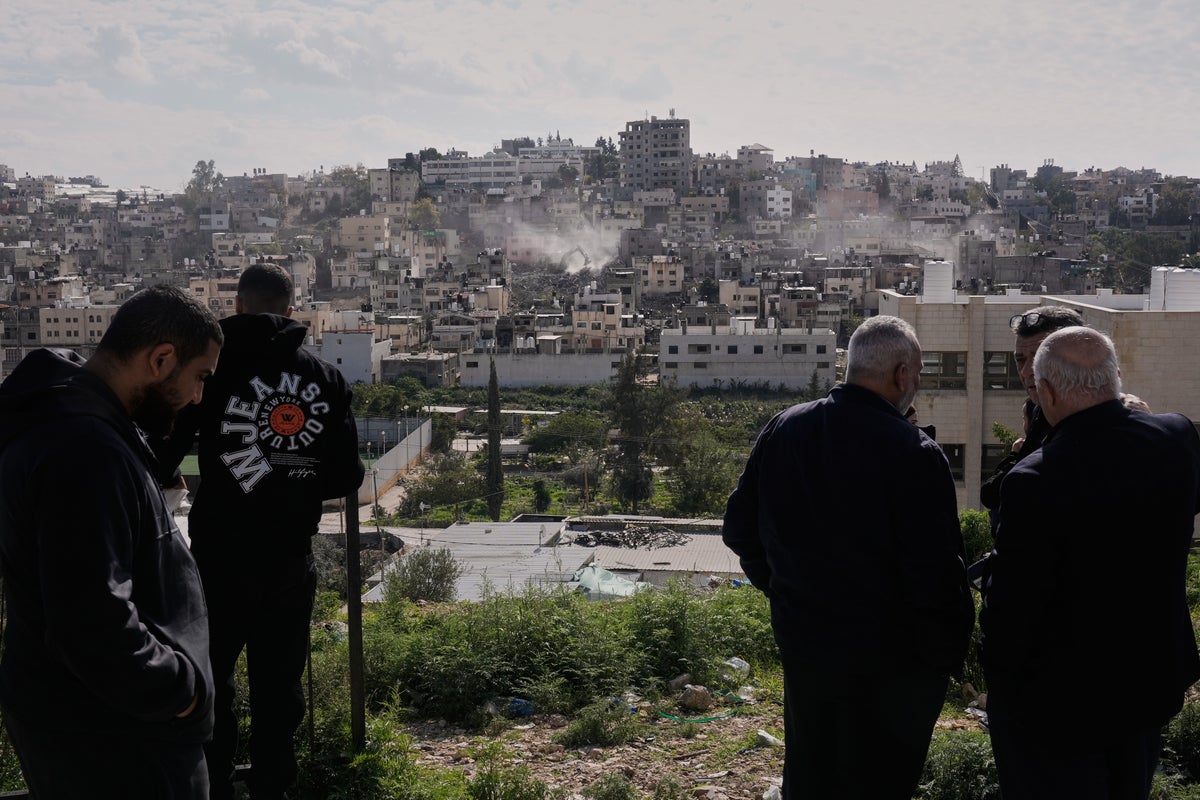 Palestinians watch as Israeli bulldozers knock down their homes in the West Bank