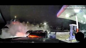 Police use squad car to push burning vehicle away from gas station