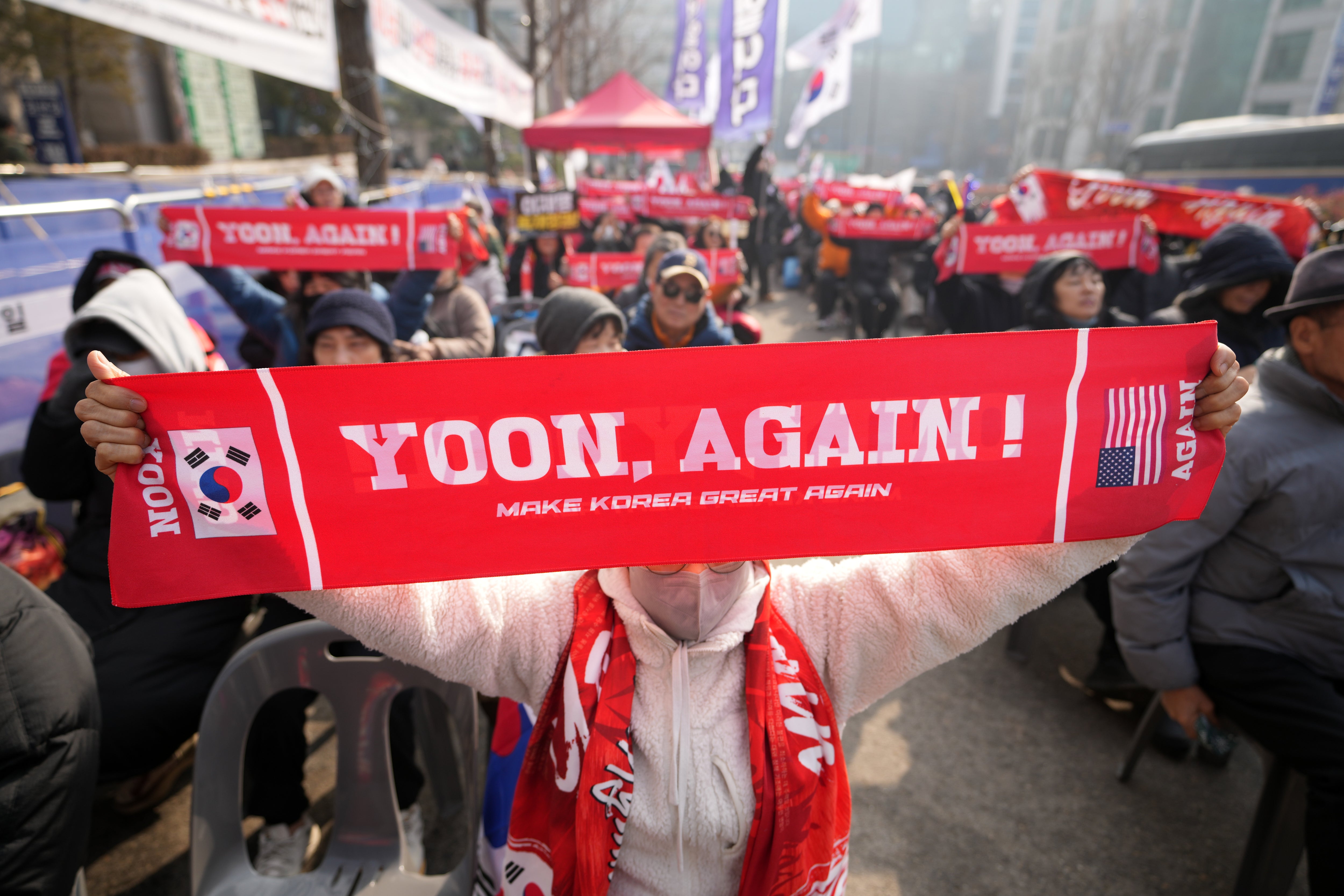 On January 16, 2026, supporters of former South Korean President Yoon Seok-yeol held signs outside the Seoul Central District Court.