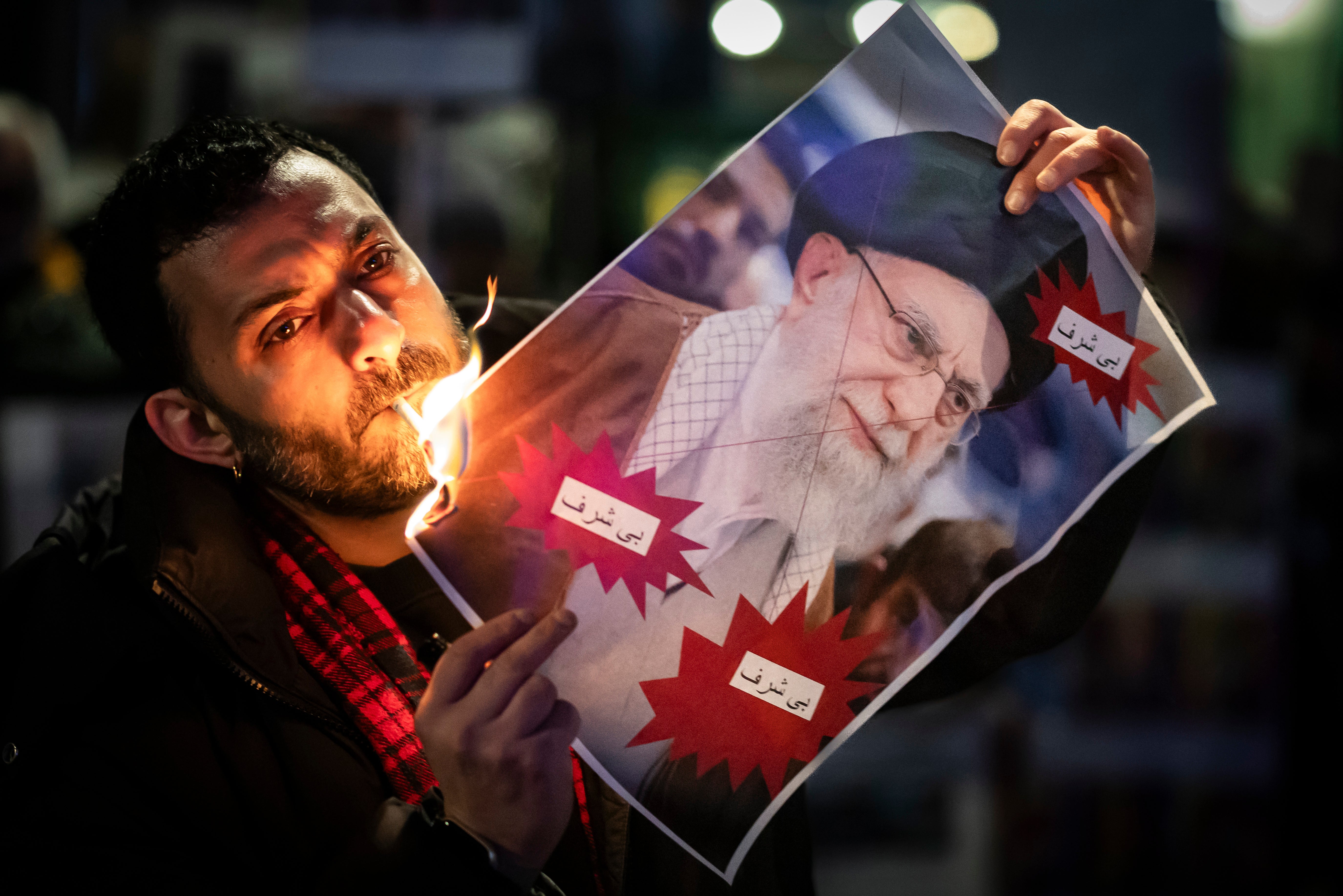 A protester burns an effigy of Ayatollah Ali Khamenei with a cigarette during a rally in support of massive nationwide demonstrations against the government in Iran, Tuesday, January 13, 2026, in Zurich, Switzerland. (Michael Buholzer/Keystone via AP)
