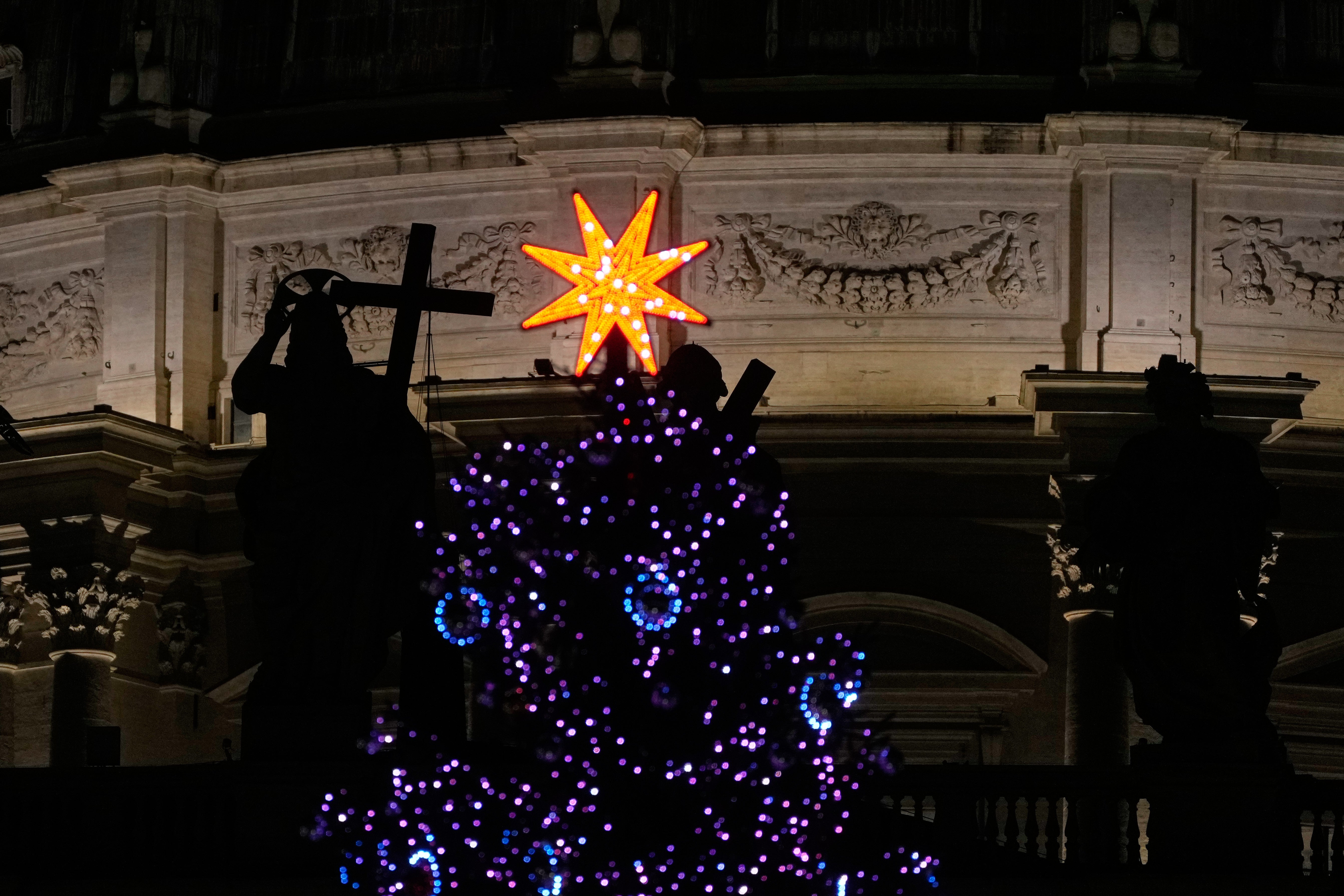 A lighted Christmas tree is seen against the backdrop of St. Peter's Basilica in the Vatican on Thursday, January 8, 2026. (AP Photo/Gregorio Borgia)